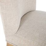 Detail view of the curved backrest upholstery fabric and stitching on Gaston stool