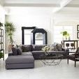 Spencer Curio Cabinet positioned next to a white cushioned armchair and glass coffee table