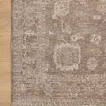 Close crop on corner of rug depicting delicate pattern near edge on light hardwood flooring