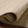 Close-up of rug rolled slightly to show thickness and wool-cotton weave detail