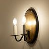 Side view of Ancram Small Double Sconce showing light glow on beige wall