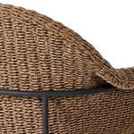 Detailed view of woven armrest curving above metal frame from a rear angle