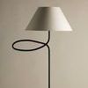 Top view focused on tapered cream lampshade with visible lamp neck and arm looping underneath