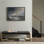 Framed ocean wave painting styled in a minimalist room with dark bench and books below