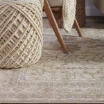 Close-up on rug design showing subtle metallic silver and gold accents within botanical motif.