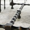 Close-up of hand-chiseled turned black leg base of Ciao Bella table showing distressed finish