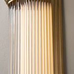 Side view showing ribbed glass texture and brass framing of wall sconce