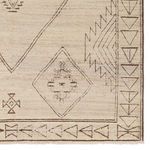 Detail of bottom corner highlighting tribal border and geometric design on taupe rug