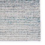 Close-up of rug edge highlighting thickness and detailed woven pattern with blue accents