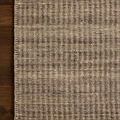 Top corner view of the rug on hardwood floor emphasizing the whip-stitched border and subtle stripe pattern