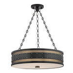 Round black metal pendant light with studded rivets, perforated brass metalwork, and frosted glass diffuser