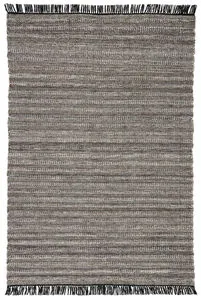 Handwoven rectangular indoor outdoor area rug in mixed black, gray, and rust tan tones with black fringe