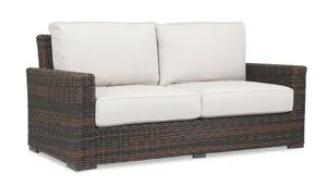 Montecito Loveseat in rich Cognac multi-colored resin wicker with cream cushions, designed for sophisticated outdoor living