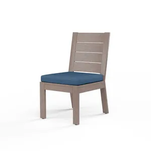 Laguna armless outdoor dining chair in hand-brushed aluminum with driftwood finish and blue seat cushion