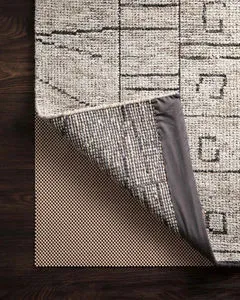 Premium 9 by 12 feet grip rug pad with waffle texture under a beige patterned rug corner lifted showing underside