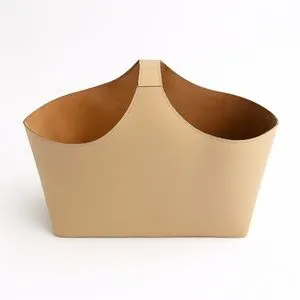 Beige Napa single handle bucket with smooth exterior and suede-like interior in a minimalist trapezoidal shape