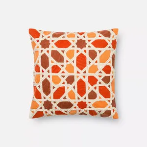 Square Akshara pillow with an orange, rust, and cream geometric pattern on textured fabric