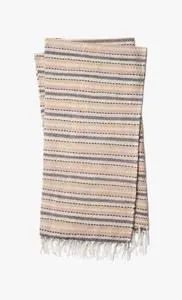 multi-colored woven throw with beige, tan, gray, and white horizontal stripes and fringed edges