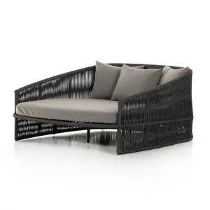 Charcoal outdoor daybed with woven rope frame, plush cushions, and angled backrest for lounging