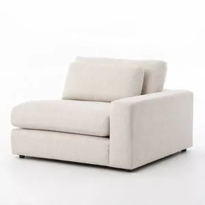 Light grey woven fabric one-armed modular sectional piece with deep, low seating and loose back cushions