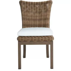 Montecito outdoor dining chair with woven rattan back and seat frame, white cushioned seat, and wooden legs