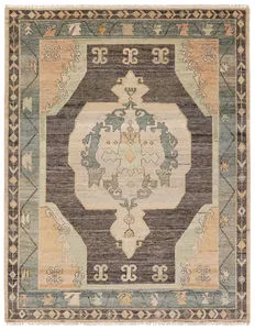 Bhima handknotted wool rug with a central medallion design in charcoal, blue, beige, and tan with intricate borders