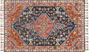 Navy and white wool rug with bold central medallion and intricate floral border with tassels