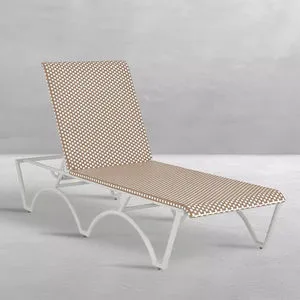 Side angle showing full chaise lounge profile and arching white metal legs on smooth floor