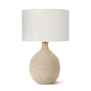 Table lamp with large rounded body wrapped in natural rope and topped with a wide white drum shade