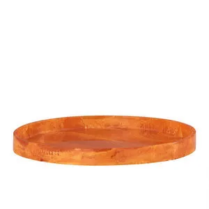 Large round serving tray in vibrant orange resin with smooth glossy finish and raised edges