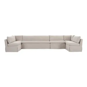 U-shaped slipcover dining banquette in neutral beige with tilted back, pillow cushions, and inverted pleat skirt