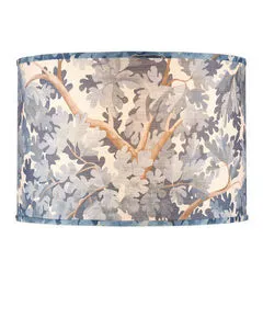 Drum-shaped blue fabric lamp shade with oak tree leaves and branches print wrapping around it