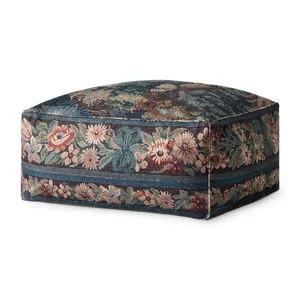 Square tapestry-inspired pouf with blue forest pattern and floral border, designed as a soft accent or footstool