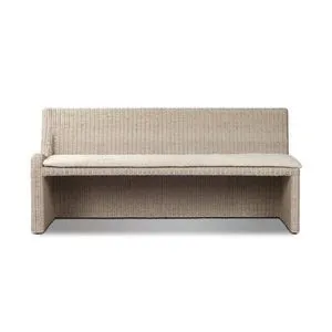 Vintage white outdoor dining banquette with woven rattan texture and a soft beige fabric seat cushion