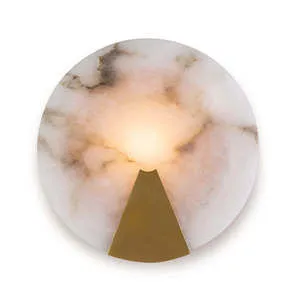 Round Houston sconce with natural alabaster diffuser and brass-finished metal frame softly glowing warm light