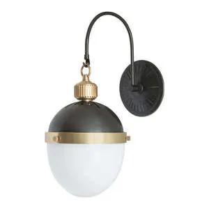 Otis Sconce with matte black curved arm, black round wall plate, matte black dome top, brass band, and white glass globe s...