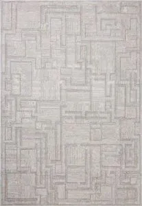 Ivory-toned modern area rug with geometric motifs and fringed edges, power-loomed for durability