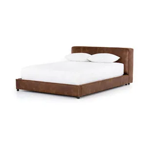 Tobacco-colored faux leather king bed with low-profile frame and plush clean-lined headboard