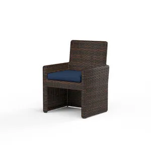 Armless Cognac multi-colored resin wicker outdoor dining chair with navy blue seat cushion