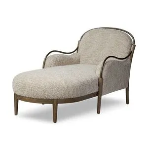 Demi Chaise shown in a three-quarter angle highlighting curved burnished brass arms and textured upholstery