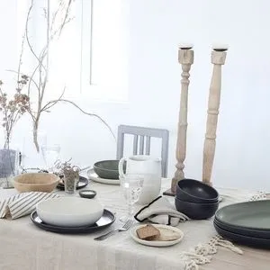 vanilla-colored fine stoneware pitcher with rounded body and sturdy handle on a kitchen table setting