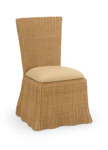 Savannah Dining Chair handwoven in natural wicker with a sand linen cushion and a flowing skirted base