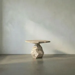 Sculptural end table with faceted geometric base and hexagonal top in textured beige marble