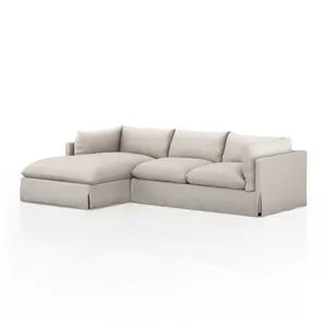 Neutral slipcovered 2-piece sectional with left-facing chaise, pillow cushions, and shelter-style arms