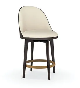 Modern counter height round stool with cream embossed vegan leather seat, dark wood tapered legs, and champagne gold metal...
