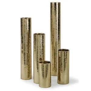 Set of five polished brass bud vases with a hammered texture, varying heights in cylindrical shapes