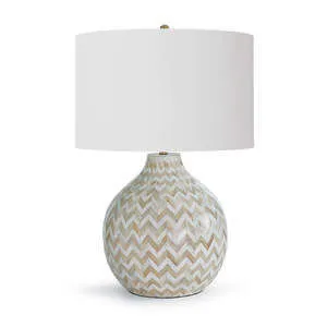 Table lamp with rounded base featuring beige and white chevron pattern and large white drum shade