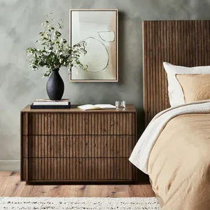 Leo Nightstand styled in bedroom with matching wood headboard and decor on top