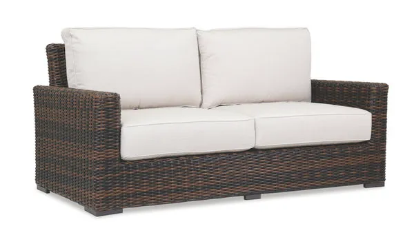Montecito Loveseat in rich Cognac multi-colored resin wicker with cream cushions, designed for sophisticated outdoor living