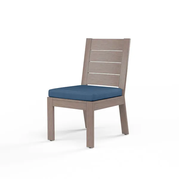 Laguna armless outdoor dining chair in hand-brushed aluminum with driftwood finish and blue seat cushion